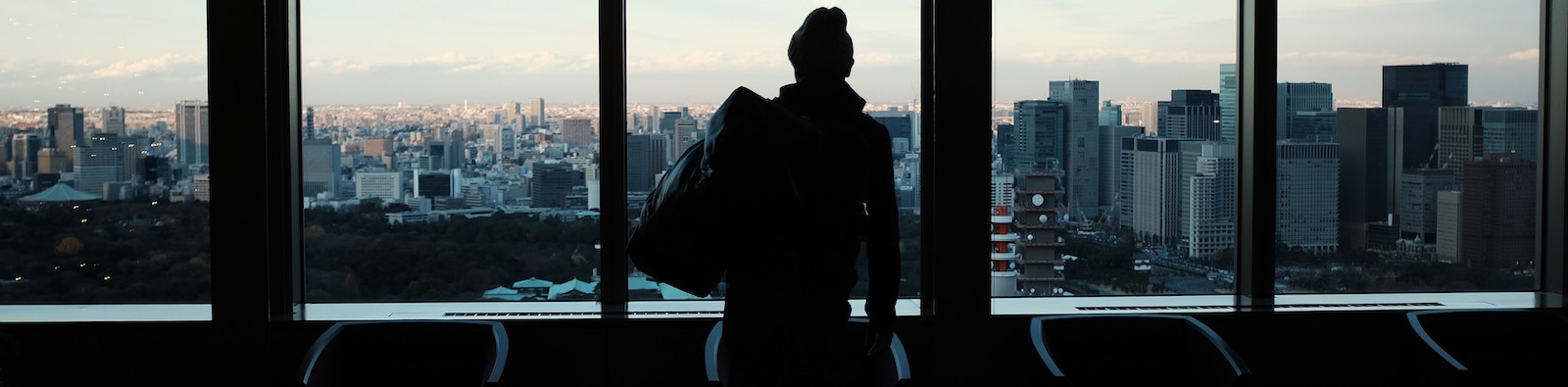 Man looking out windows at skyscrapers