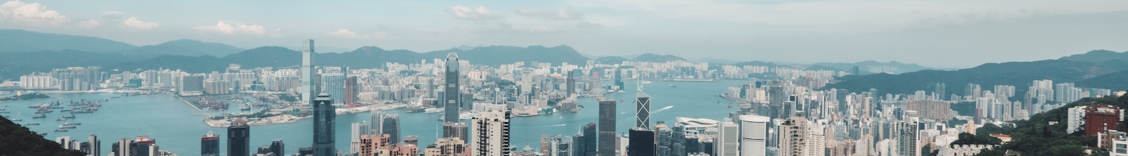 City with tall buildings, mountains, and a bay.