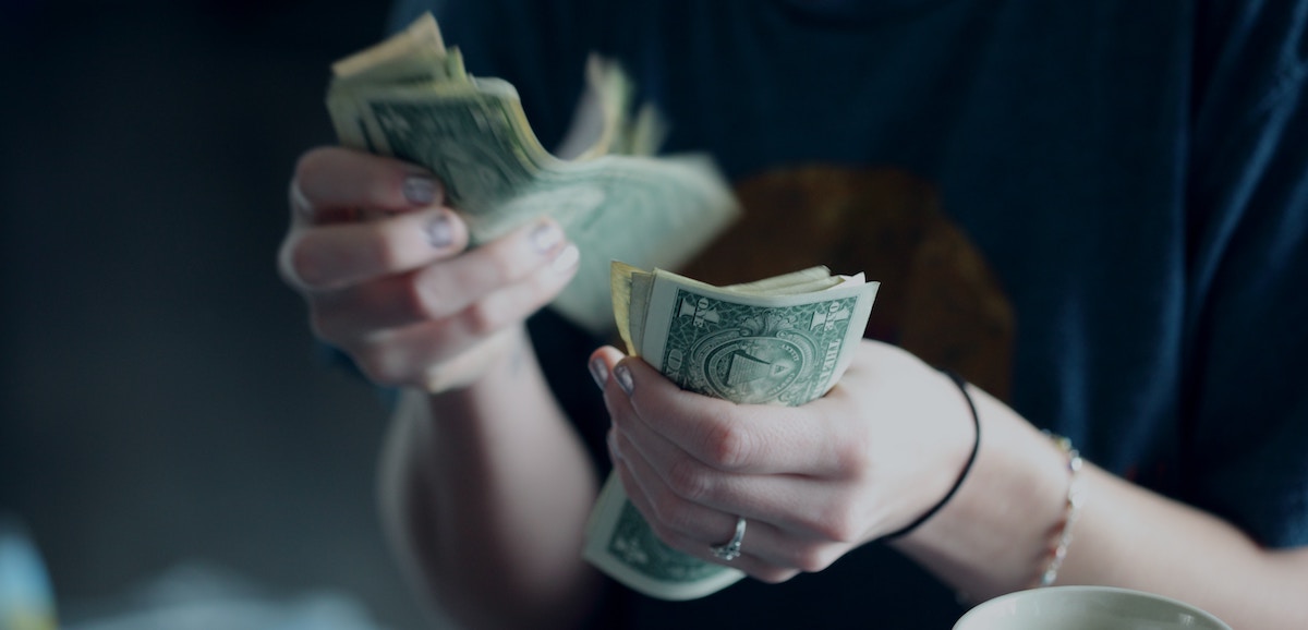 Lady counting dollar bills.